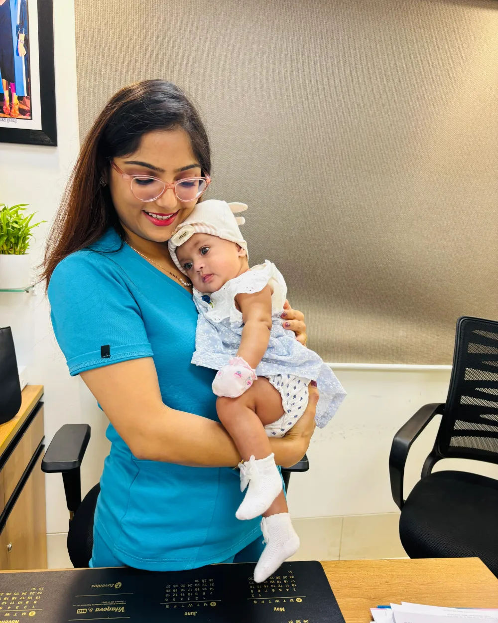 Dr. Rashmi Bhamare in scrubs, holding a baby